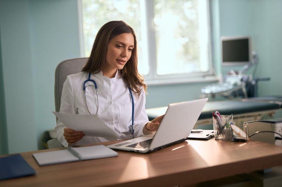 A physician reviewing records at her desk